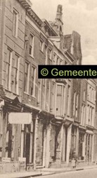 <p>Detail van een foto van de Oudestraat van voor 1917. Oudestraat 100 en 102 zijn nog gescheiden en op de begane grond voorzien van een eigen winkelpui (Stadsarchief Kampen). </p>
